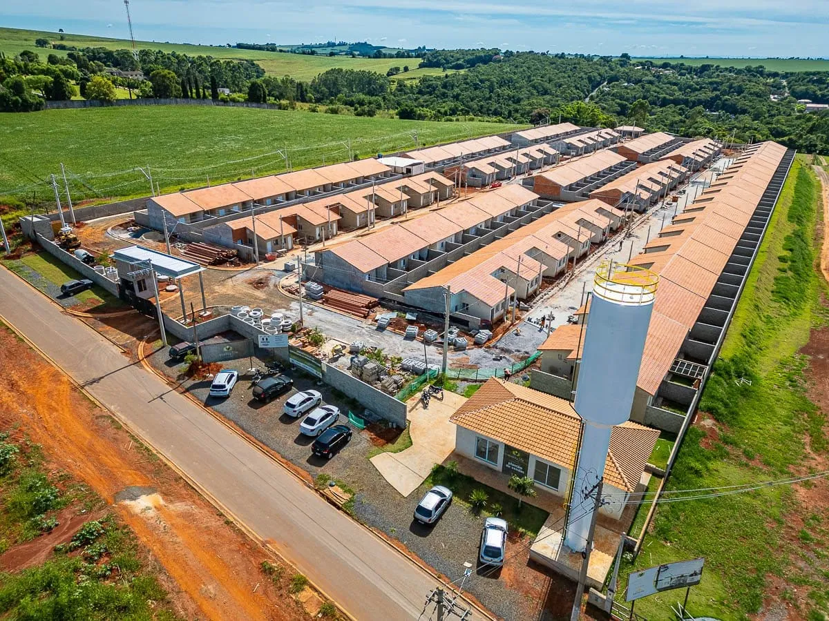 Vista aérea do Quality Life Itapê com a caixa d'água, o estacionamento e as quadras de casas