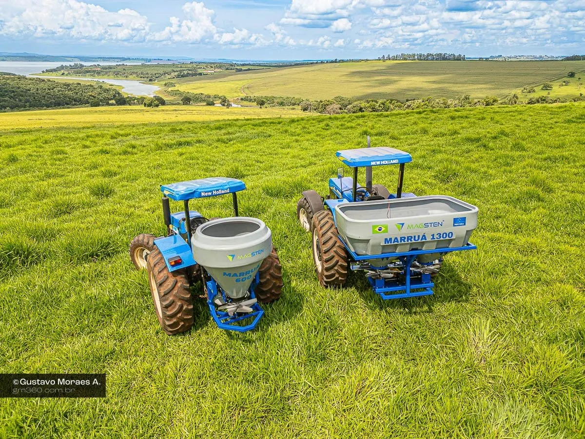 Dois tratores com distribuidores da Magsten em um pasto, fotografados de cima por drone