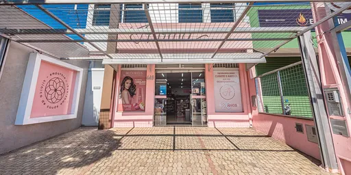 Fachada rosa da Aroma Perfumaria, com portas de vidro e painéis decorativos dos dois lados da entrada