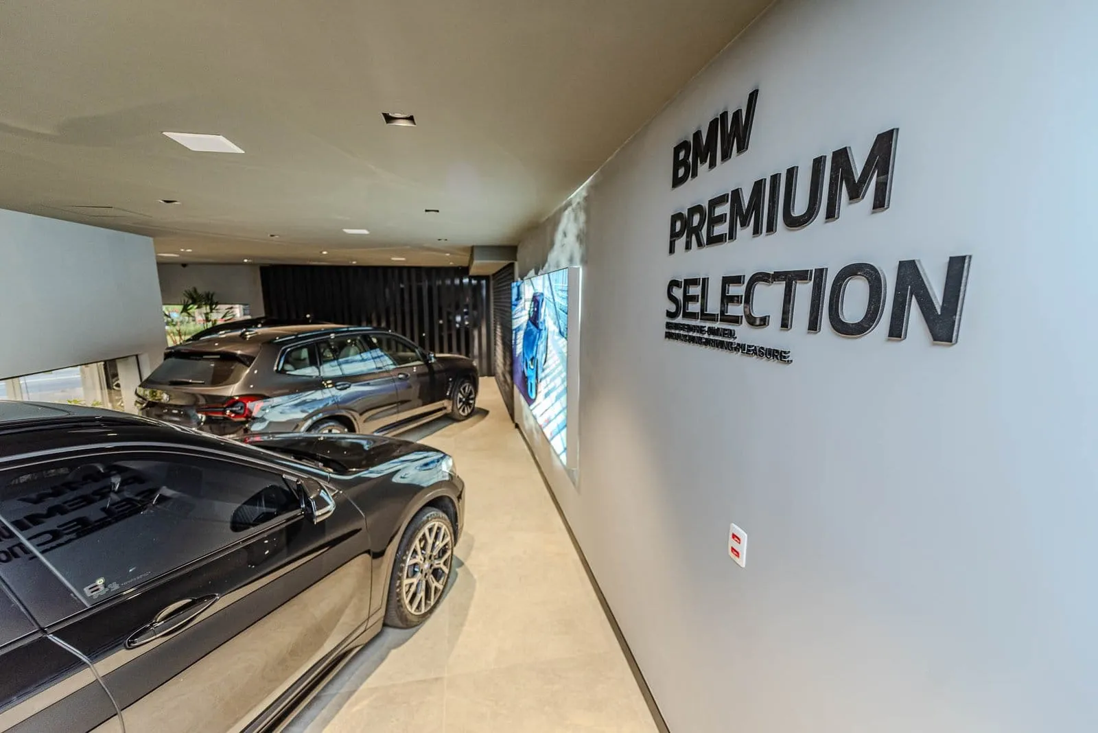 Corredor da área BMW Premium Selection com carros enfileirados junto à parede