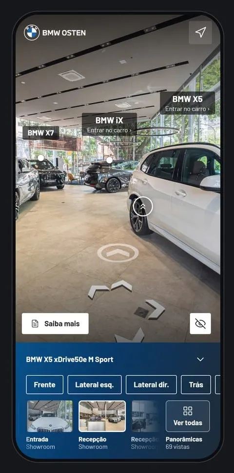 Celular com o tour 360° da BMW Osten Perdizes no showroom, com o X5 branco à direita, um ponto redondo de navegação com seta sobre a lateral do carro, a seta fixa no chão à frente da câmera, as setas em V em volta dela, os rótulos do X5, do iX e do X7, os botões Saiba mais e olho e a galeria com os chips Frente, Lateral esq., Lateral dir. e Trás