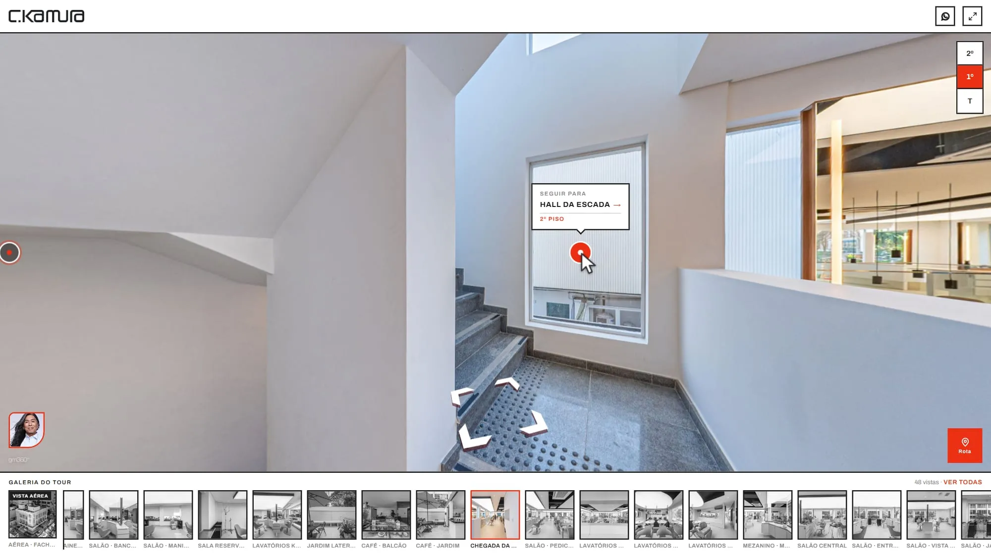 Escada no 1º piso do tour com o ponto de navegação em vermelho e o aviso Seguir para Hall da Escada, com a linha 2º Piso em vermelho, e o seletor de pisos à direita com o 1º marcado