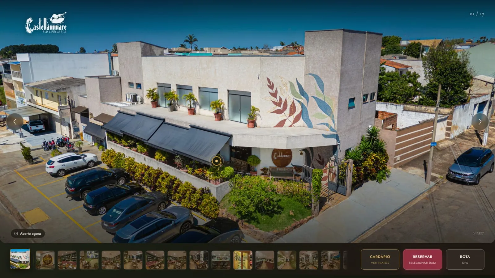 Vista aérea da Cantina Castellammare no tour, com a fachada de esquina, os toldos, o jardim e o estacionamento, e a miniatura da vista aérea fixada no início da galeria