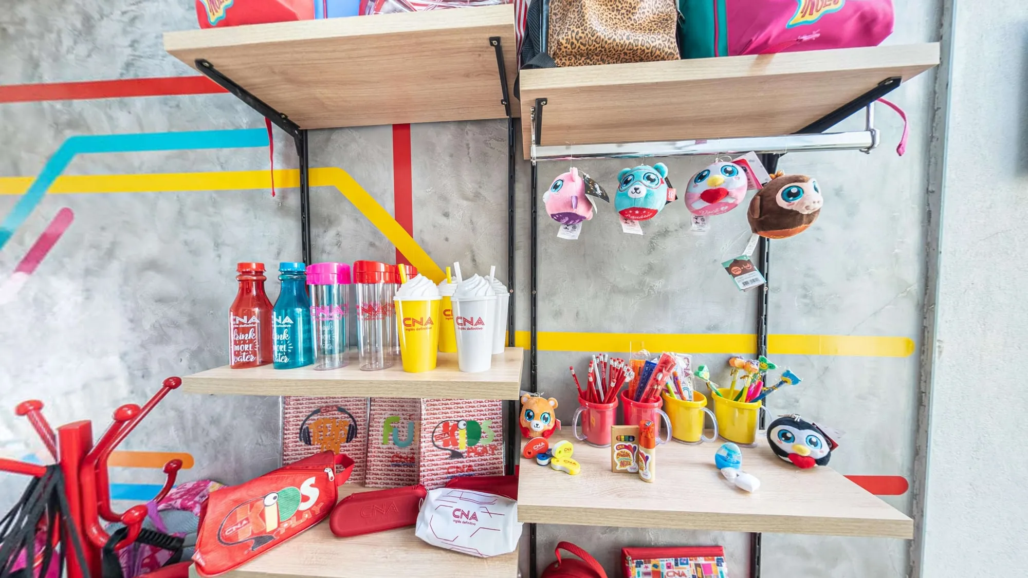 Loja do CNA Itapetininga, com prateleiras de garrafas, copos, pelúcias e mochilas com a marca da escola