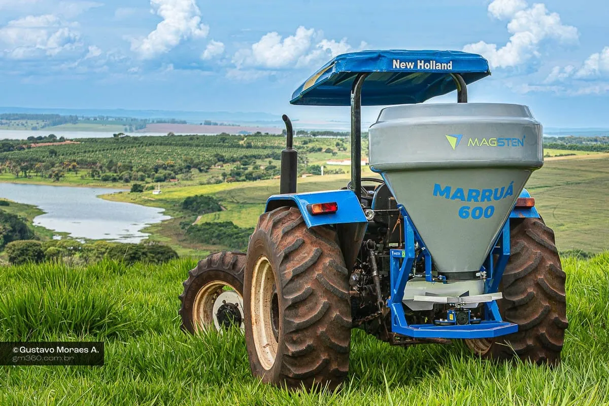 Marruá 600 da Magsten acoplada a trator, com represa e campo ao fundo