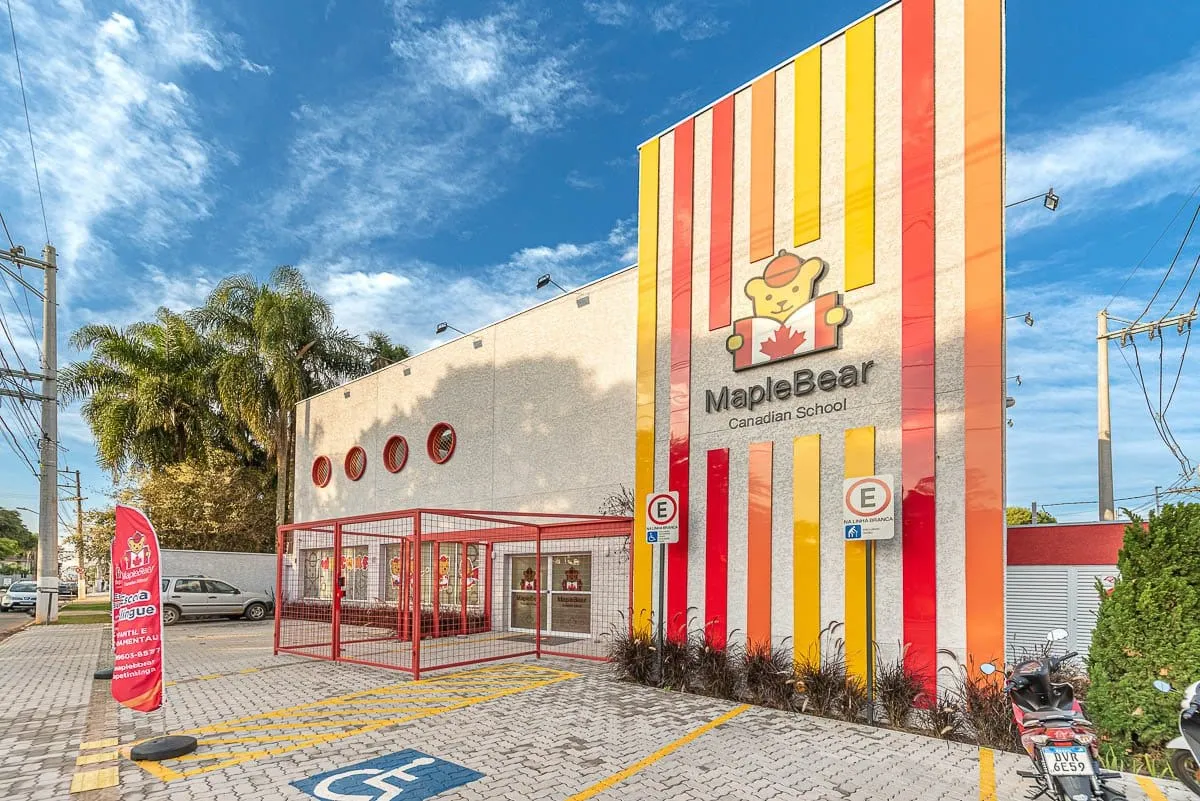 Fachada listrada em vermelho, laranja e amarelo da Maple Bear Itapetininga