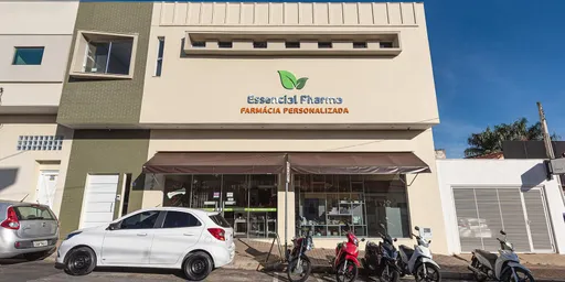 Fachada da Essencial Pharma em Itapetininga, com motos e um carro estacionados em frente