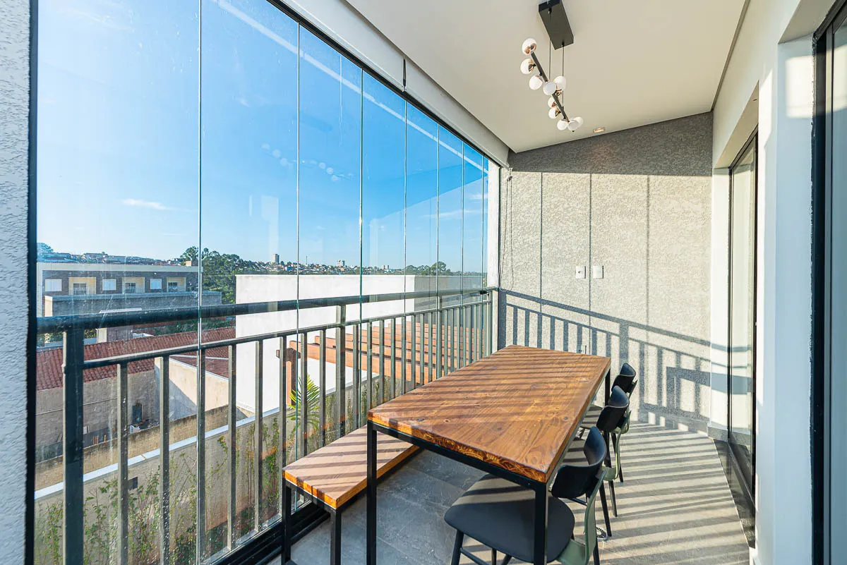 Varanda gourmet com mesa e vista da cidade do decorado Haus Residence Club