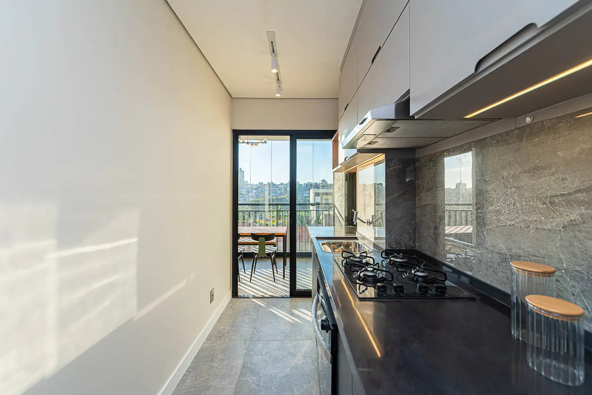 Cozinha com vista panorâmica para a varanda do decorado Haus Residence Club