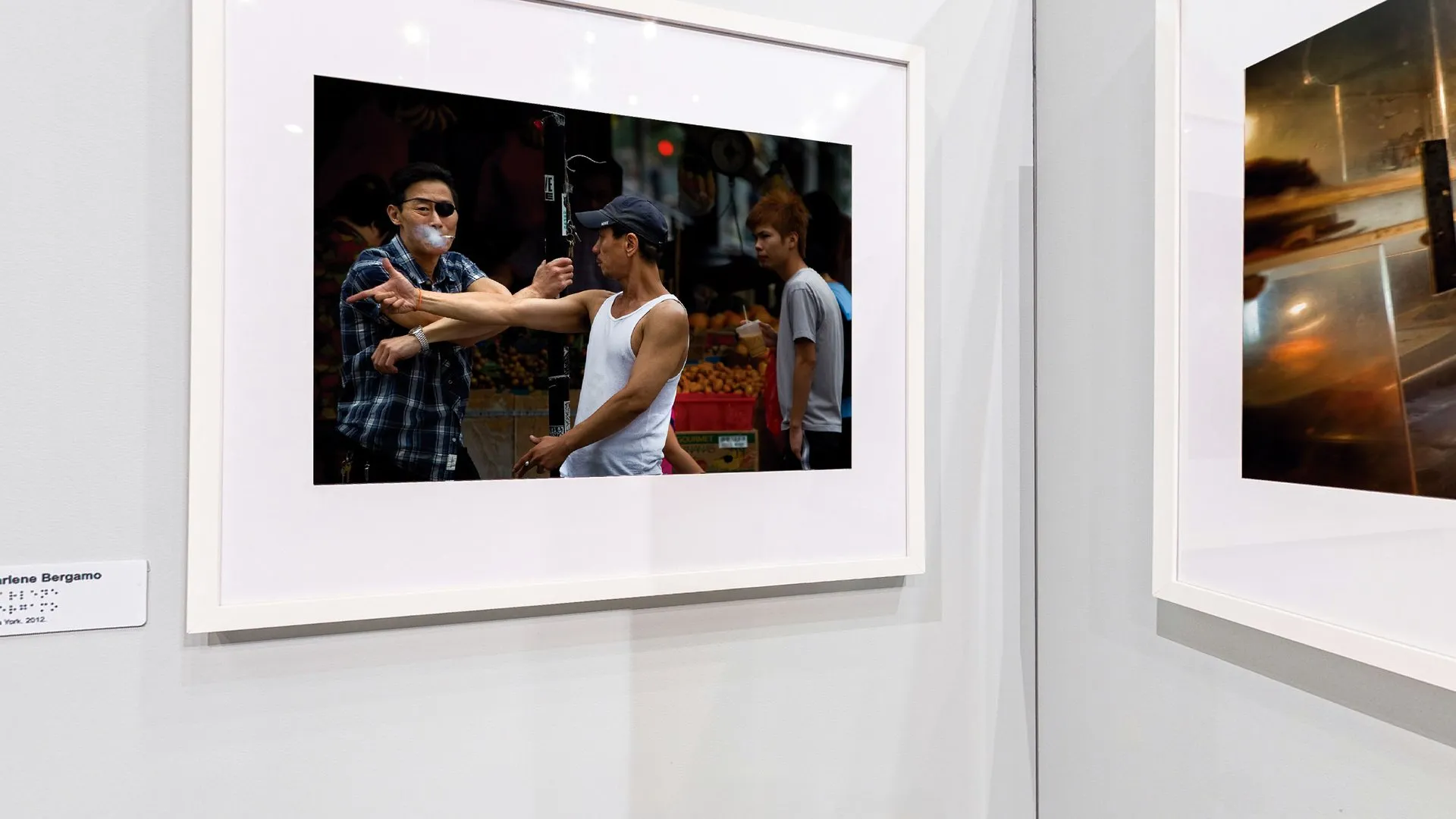 Fotografia colorida de Marlene Bergamo em Chinatown, Nova York, emoldurada no biombo da exposição Herança Compartilhada
