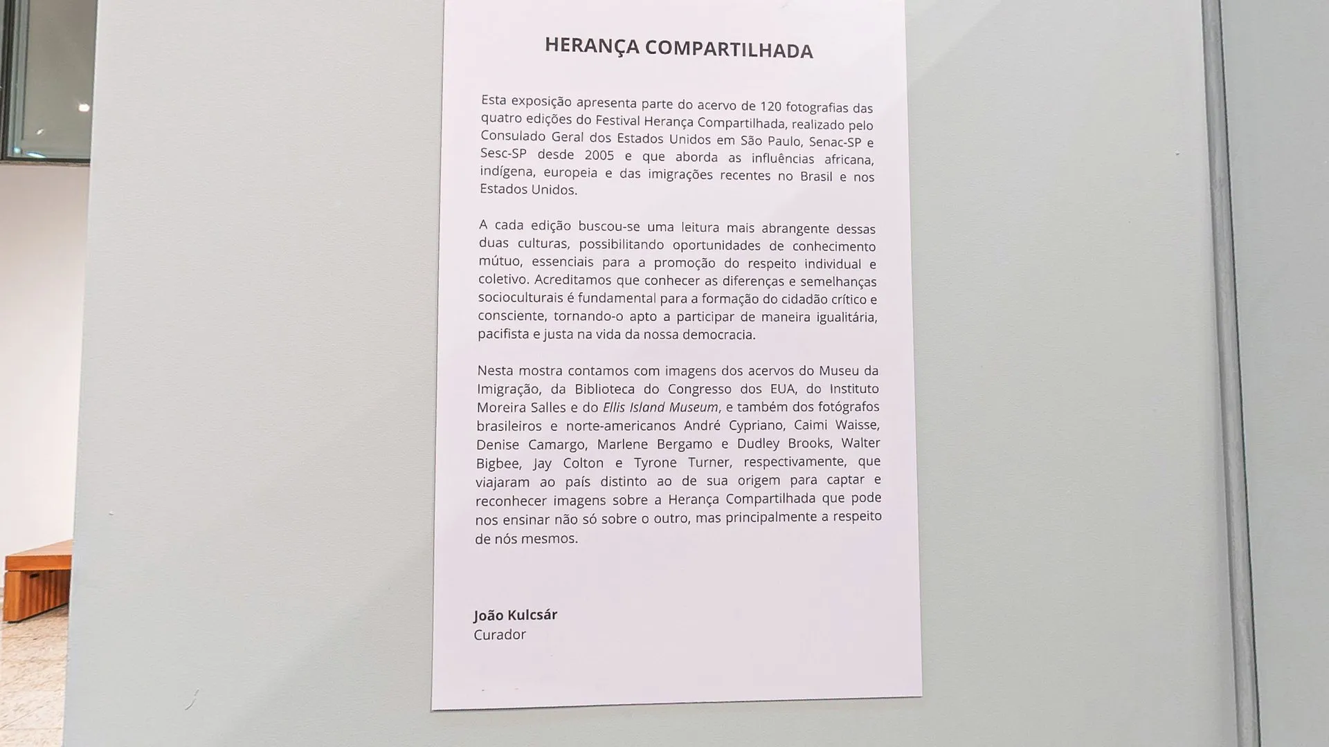 Painel com o texto curatorial da exposição Herança Compartilhada, assinado pelo curador João Kulcsár