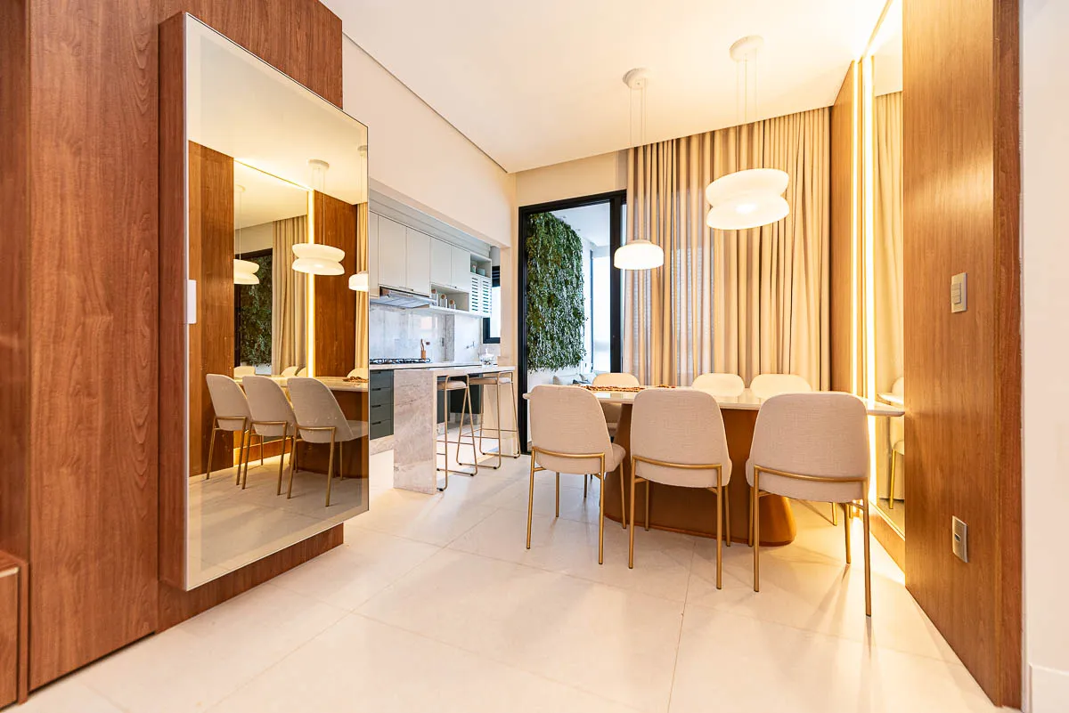 Sala de jantar com cozinha e jardim vertical ao fundo do decorado Horizon Vila Rosa