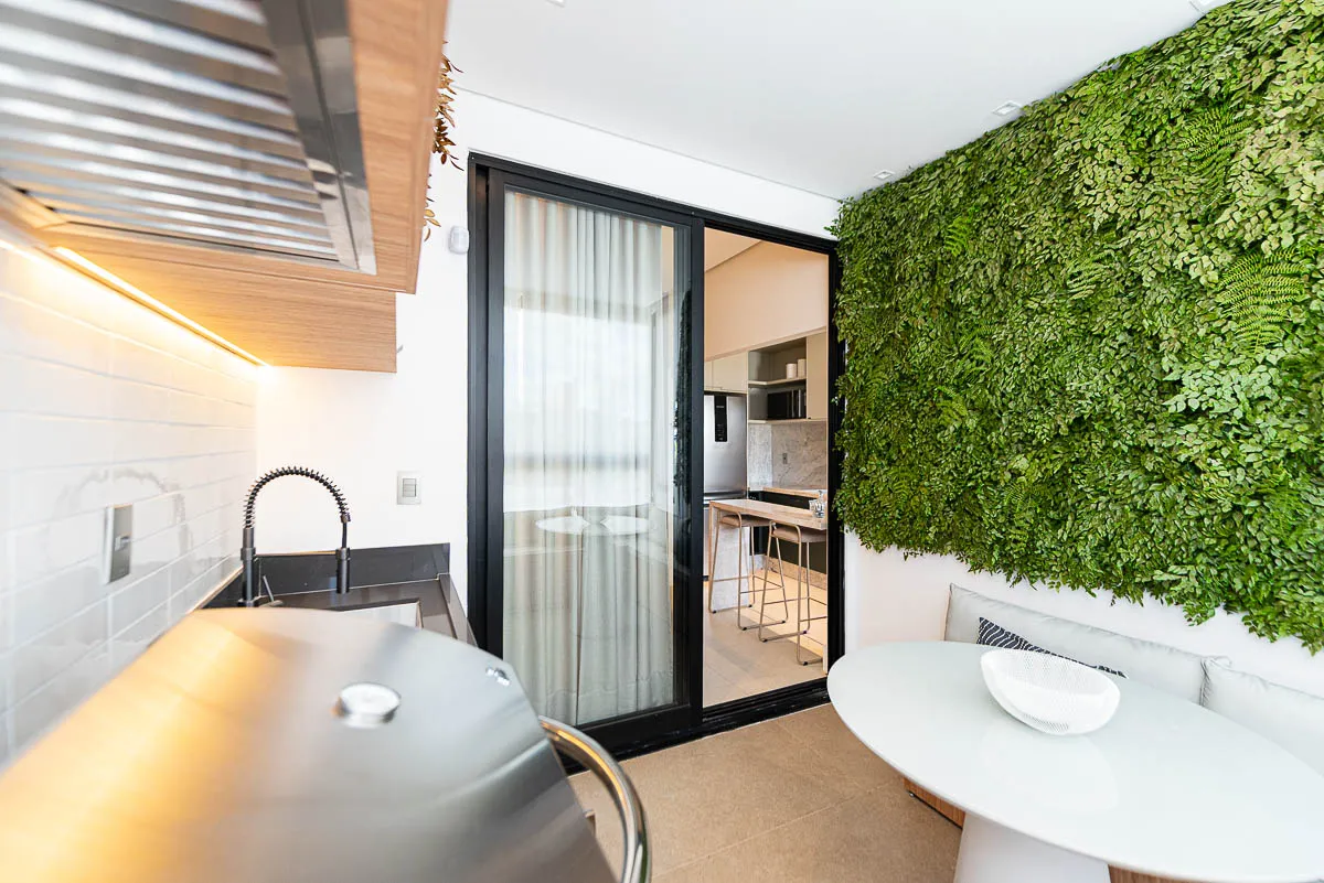 Varanda gourmet com jardim vertical do decorado Horizon Vila Rosa