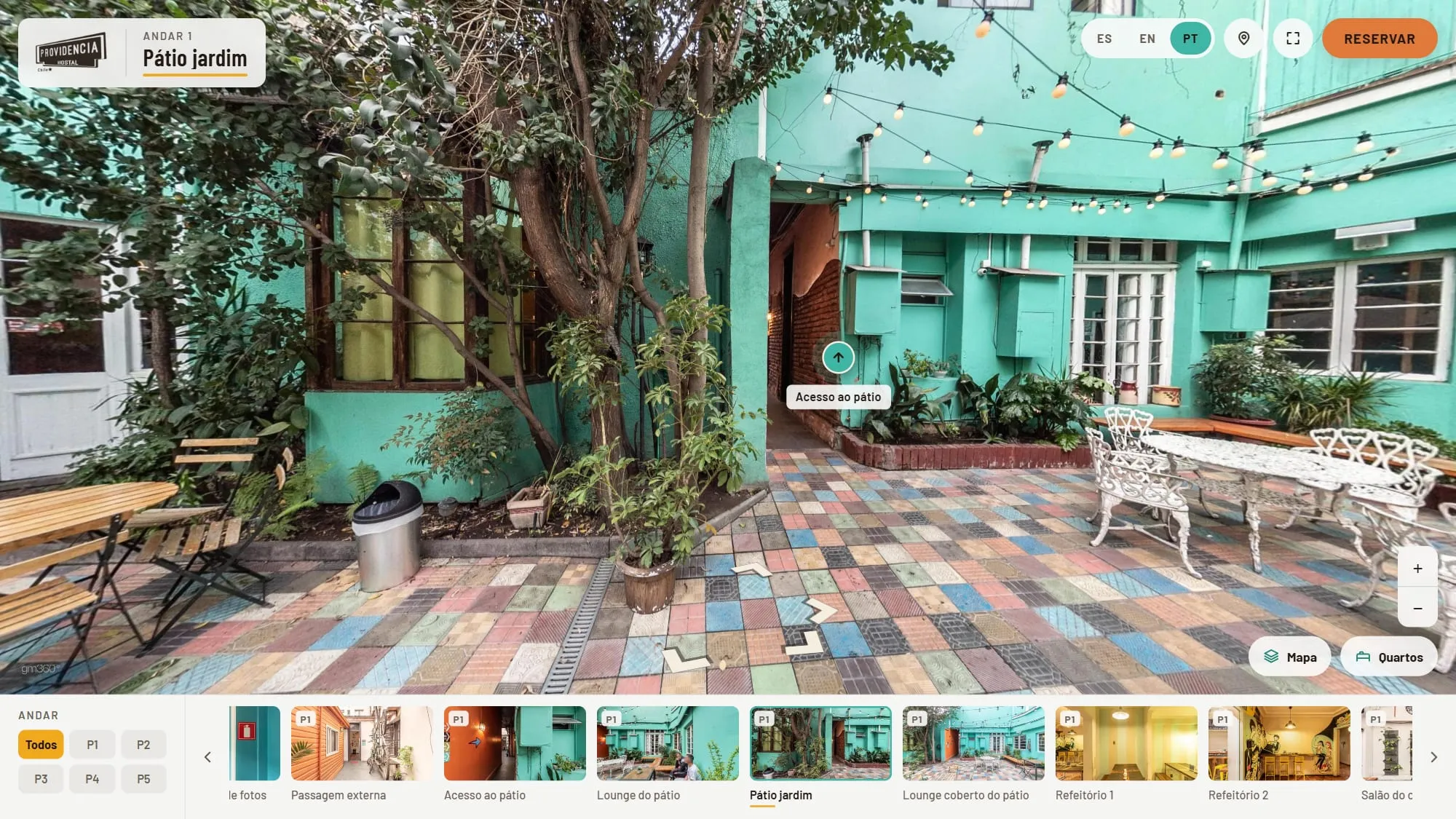 Pátio jardim do Hostal Providencia no tour 360° próprio, com piso de ladrilhos coloridos, árvores, varal de lâmpadas e paredes verde-água, o logo do hostal e o nome da cena no alto, os idiomas, o pino de rota e o botão Reservar no cabeçalho, as setas no piso e a galeria com filtro por andar embaixo