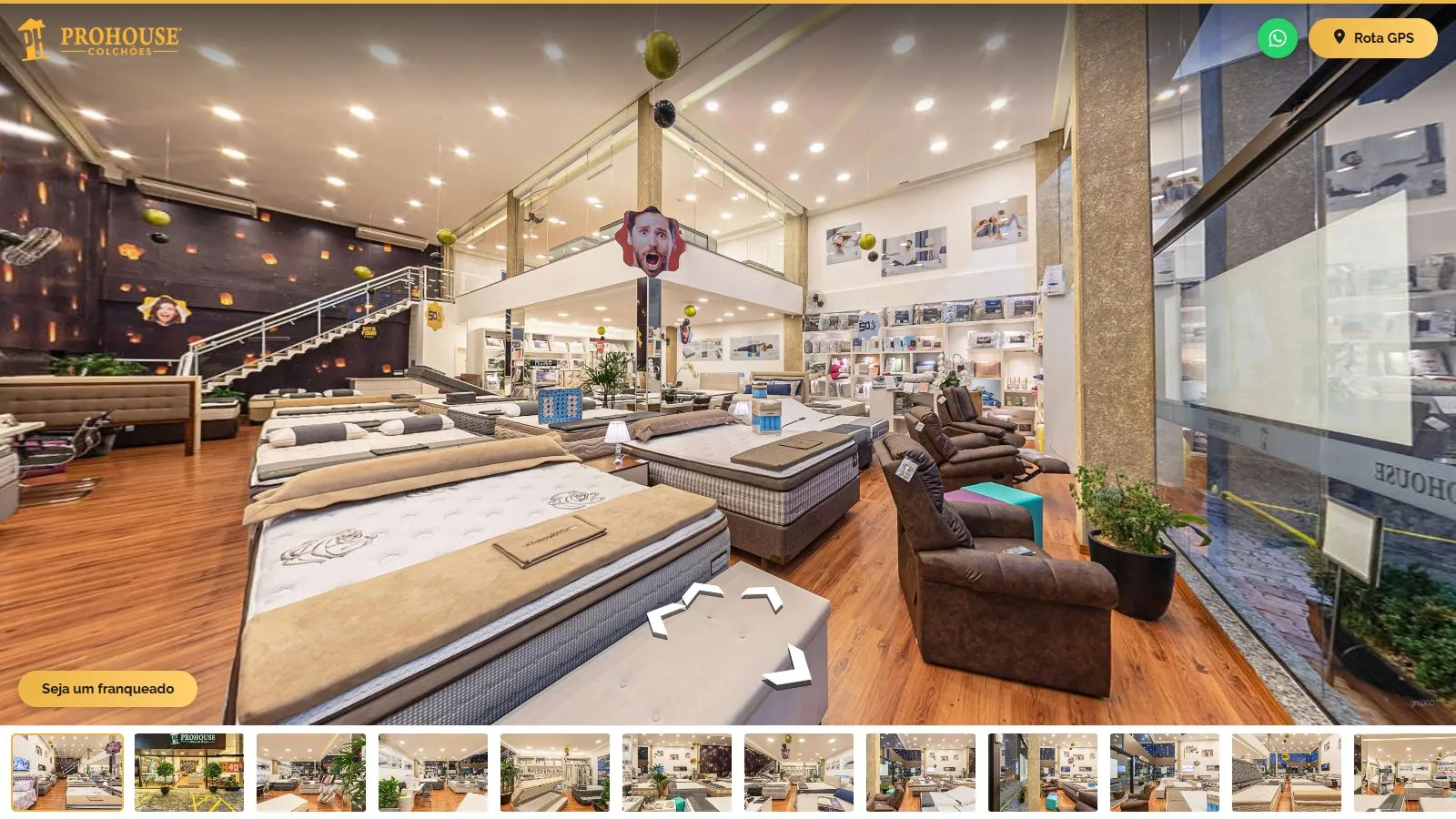 Tour 360° aberto na entrada da matriz, com colchões e camas box em primeiro plano, poltronas reclináveis junto à vitrine, a escada para o mezanino ao fundo, o logotipo da Prohouse no alto, os botões de WhatsApp e Rota GPS, o botão Seja um franqueado e a galeria de miniaturas embaixo