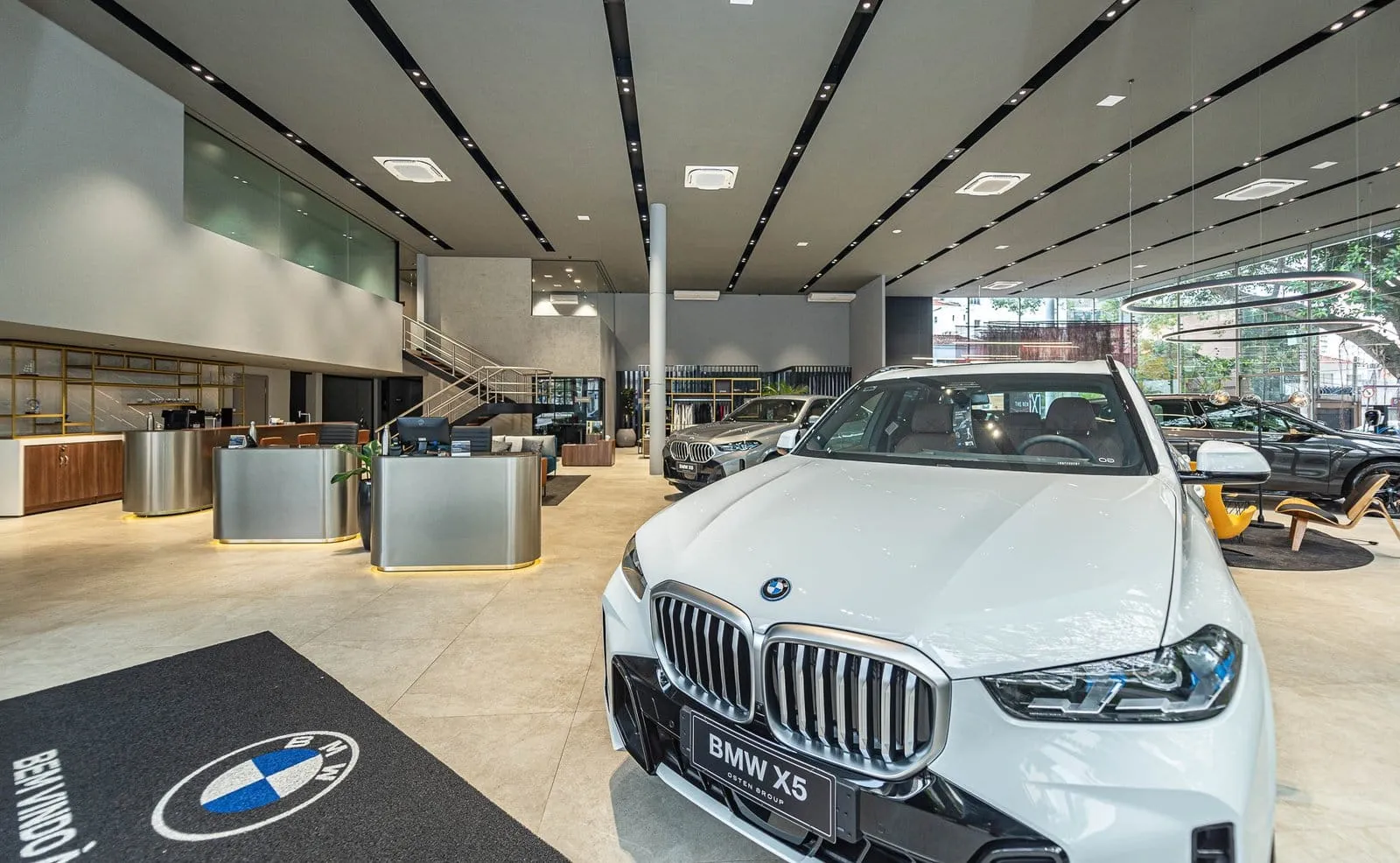BMW X5 branco sobre tapete com o logotipo da marca no showroom da BMW Osten Perdizes